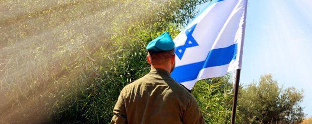 Israeli,Soldier,Stands,In,A,Field,With,Flag,Of,Israel